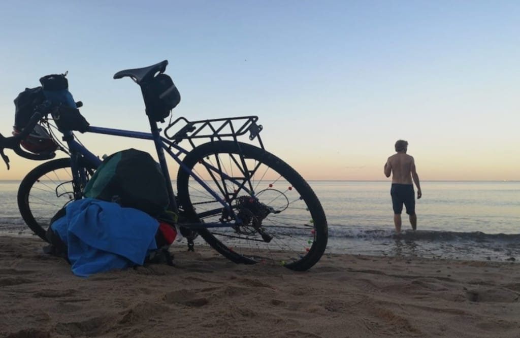 Picture shows Alastair's bike on the beach and Alastair taking a swim