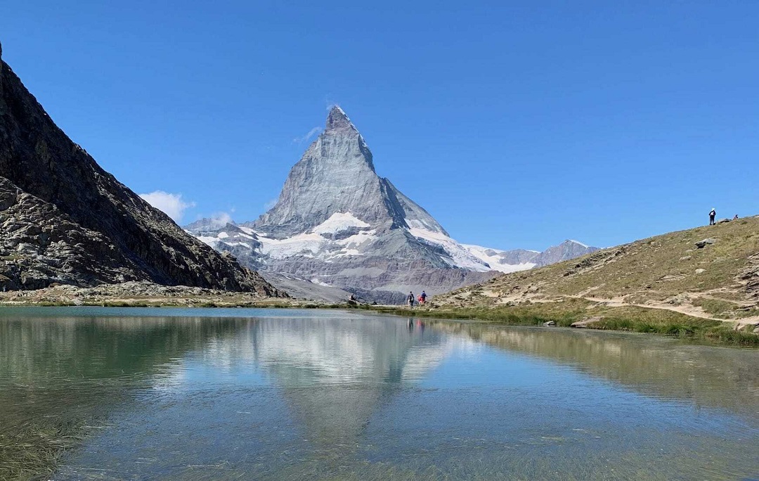 Rocky mountain reflected on a body of water in day light