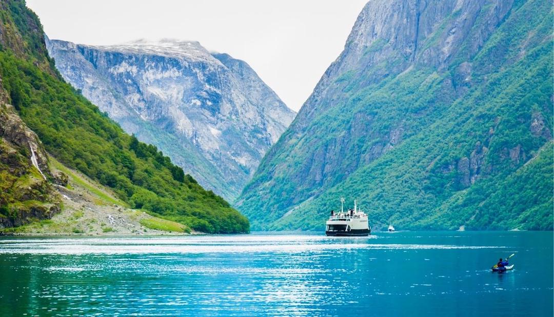 A boat heading along a Norwegian Fjord