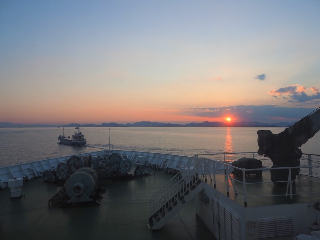 Picture is taken from the bow of the ferry with the sea and low craggy hills in the distance.